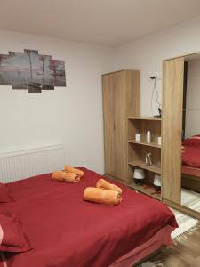 哈卡尼Gál Apartmanház的一间卧室配有红色的床和2条毛巾
