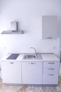 巴勒莫Clambè的白色的厨房设有水槽和炉灶。