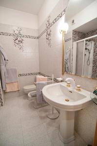 SorisoHotel Ristorante Al Sorriso的白色的浴室设有水槽和卫生间。