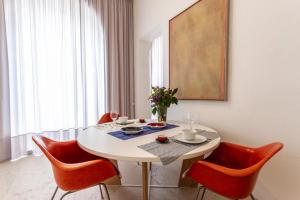 曼托瓦PALAZZO BECCAGUTTI CAVRIANI - Gallery Suite e Frescoes Suite的一间设有白色桌子和红色椅子的用餐室
