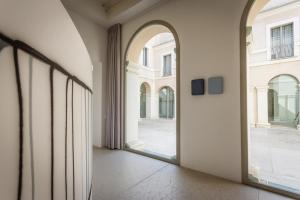 曼托瓦PALAZZO BECCAGUTTI CAVRIANI - Gallery Suite e Frescoes Suite的大楼内有大窗户的空走廊