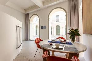 曼托瓦PALAZZO BECCAGUTTI CAVRIANI - Gallery Suite e Frescoes Suite的一间带桌子和红色椅子的用餐室