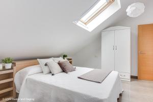 科尔库维翁Apartamento Playa de Quenxe的白色卧室设有床和天窗
