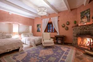 瓦斯卡坎波阿祖尔化斯卡酒店的一间卧室设有壁炉、一张床和一把椅子