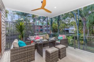 布里斯班Park Avenue Townhouse Retreat Brisbane Sleeps 10的阳台的天井配有桌椅