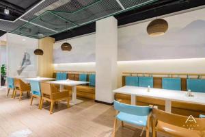 上饶亚朵酒店上饶中心广场店的一间配备有桌子和蓝色椅子的用餐室