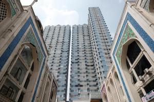 德波RedLiving Apartemen Saladdin Mansion - RAN Management的一座高大的公寓楼,位于一座大建筑前