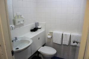 曼哲拉曼杜拉中庭酒店的白色的浴室设有卫生间和水槽。