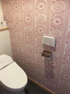 AsahiGuesthouse Kazenowa的一间带卫生间和墙壁的浴室