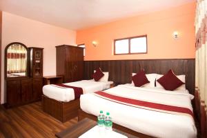 加德满都Hotel Holiday Taj (p) Ltd的酒店客房 - 带两张带红色枕头的床