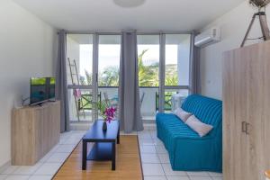 布康卡努Boucan Beach Joli studio vue mer à Boucan Canot的客厅配有蓝色的沙发和电视