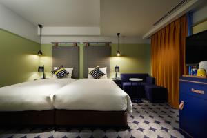 横滨Hotel Resol Yokohama Sakuragicho的卧室配有一张白色大床和一把椅子