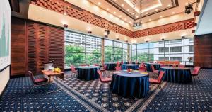 新加坡新加坡史各士皇族酒店的大型客房设有桌椅和窗户。