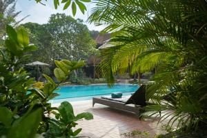 沙努尔布玛斯酒店的毗邻度假酒店的带躺椅的游泳池