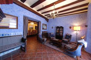Las Cuevas de CañartAparthotel SPA Don Iñigo de Aragón的客厅设有蓝色的墙壁、椅子和沙发