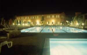 圣温琴佐圣卡塔林纳酒店的一座大型游泳池,晚上与大楼相连