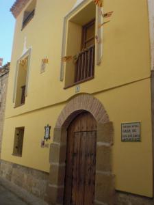 AlborgeCasa De Los Diezmos的黄色的建筑,设有木门和窗户