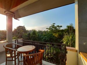 乌布Jero Ratna Homestay的设有一个配有桌椅并享有美景的阳台。