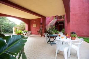 巴里萨尔多斯特拉迪雷斯特住宅酒店的一个带桌椅的庭院和粉红色的墙壁