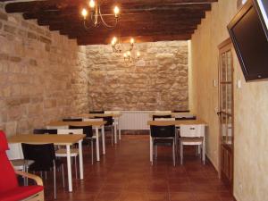 AlborgeCasa De Los Diezmos的一间设有桌椅的用餐室和砖墙