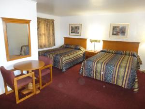 绿湾陶尔汽车旅馆的酒店客房设有两张床、一张桌子和镜子