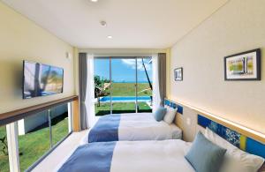 宫古岛Feliz Villa Suite Irabujima Sawada的带大窗户的客房内的两张床