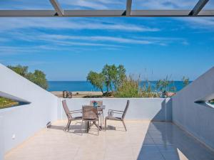 普拉坦斯Blue Oyster Villas的一个带桌椅的庭院和大海
