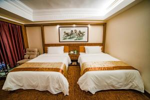 广州广东南洋长胜酒店的酒店客房,配有两张床和椅子