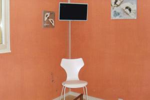 内拉克chambre d'hotes a nérac的电视机前的白色椅子