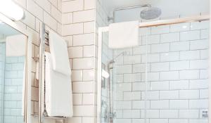 圣布雷拉德金沙酒店的浴室铺有白色地铁瓷砖,配有淋浴。