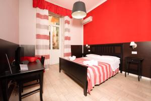 那不勒斯Napoli Experience的一间卧室设有一张床和红色的墙壁