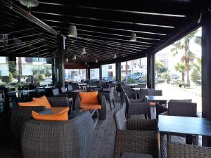 盖尼特拉Golden Ashraf Apartment的一间空餐厅,配有桌椅和窗户