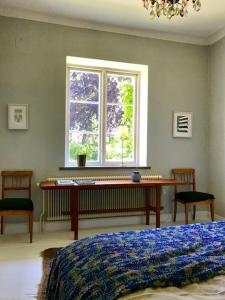 SandbyLiv på Österlen Bed&Breakfast的卧室配有一张床,窗户前设有一张书桌