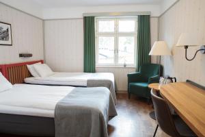 斯德哥尔摩辛肯丹姆STF酒店的酒店客房,配有两张床和椅子