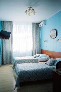 特维尔奥克特亚布斯卡亚酒店的蓝色墙壁客房的两张床