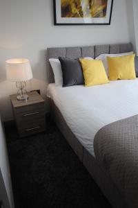 哈利法克斯Halifax House, Studio Apartment 214的一间卧室配有一张带黄色枕头和灯的床。