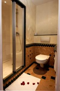 瓦尔扎扎特瓦尔扎扎特宜必思酒店的浴室设有卫生间和带红色玫瑰花瓣的淋浴。