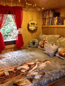卡马森'Morris' the shepherd's hut with woodland hot tub的一间卧室配有一张带绘画的床铺