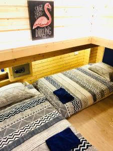 曼谷Blu Cabin Gay Poshtel的两张睡床,放在一个房间里架子下