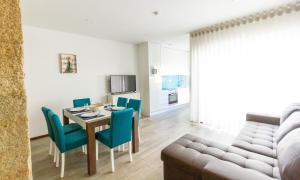 波瓦-迪瓦尔津Apartamentos Castelo的用餐室以及带桌椅的起居室。