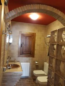 卡斯特里尔Finca Los Villegas的一间带卫生间和水槽的浴室以及一扇木门。