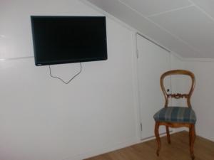 特罗尔海坦特罗尔海坦住宿加早餐民宿的一间房间,墙上有椅子和电视