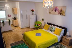 布加勒斯特Collosal Studio的一间卧室配有黄色的床和绿色椅子