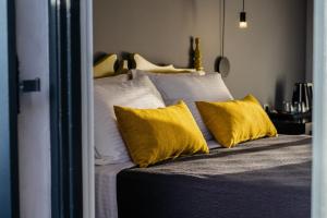 纳夫普利翁Aethra Boutique Rooms的一间卧室配有一张带黄色枕头的床