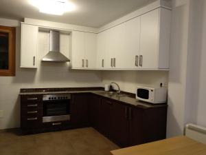 普埃尔托德尔松Apartamento en Primera Linea的厨房配有白色橱柜和微波炉