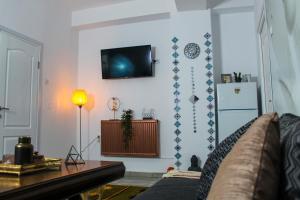 布加勒斯特Nirvana Apartament的客厅配有沙发和墙上的电视