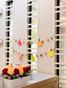 斯里曼绒Seri Manjung HomeStay @Spacious Family Home的花朵在窗边的带圣诞灯的花