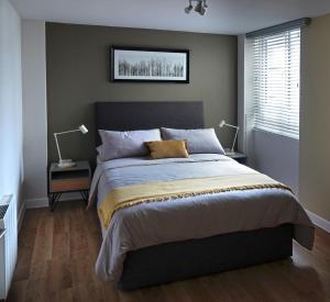 卡迪夫Modern One Bedroom Apartment in Cardiff Bay的一间卧室配有一张大床和两盏灯。