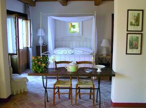 皮恩扎Le Traverse的一间卧室配有桌子和一张带天蓬的床