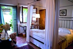 皮恩扎Le Traverse的一间卧室配有一张床、一张书桌和一个窗户。